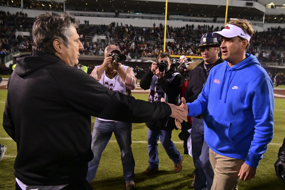 Nov 25, 2021; Starkville, Mississippi, USA; Mississippi State Bulldogs head coach Mike Leach and Mississippi Rebels head coach Lane Kiffin shake hands after the game at Davis Wade Stadium at Scott Field. Mandatory Credit: Matt Bush-USA TODAY Sports