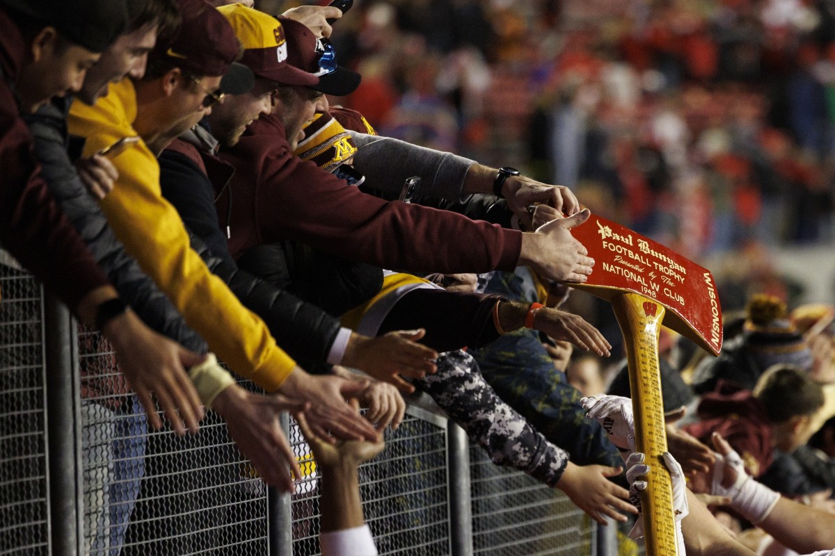 Nov 26, 2022; Madison, Wisconsin, USA; The Minnesota Golden Gophers fans celebrate with the Paul Bunyan Axe following the game against the Wisconsin Badgers at Camp Randall Stadium. Mandatory Credit: Jeff Hanisch-USA TODAY Sports