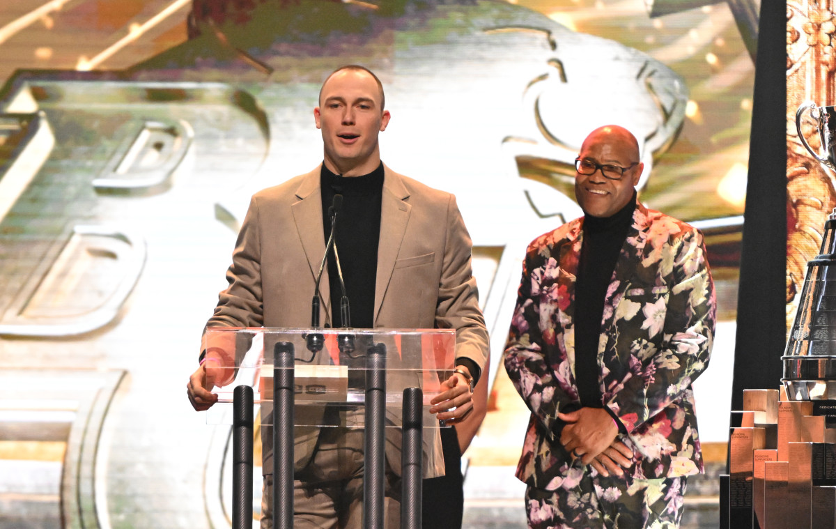 Nov 16, 2023; Niagra Falls, Ontario, CAN; British Columbia Lions defensive lineman Mathieu Betts speaks after winning the Most Outstanding Defensive Player award during the CFL Awards at Fallsview Casino & Resort. At right is presenter and former CFL player Grover Covington. Mandatory Credit: Dan Hamilton-USA TODAY Sports