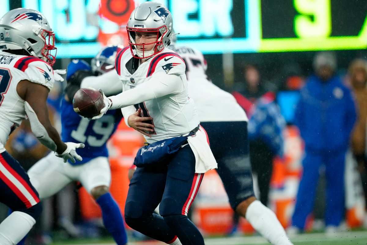 New England Patriots quarterback Bailey Zappe (4) prepares to handoff to New England Patriots running back Rhamondre Stevenson (38)