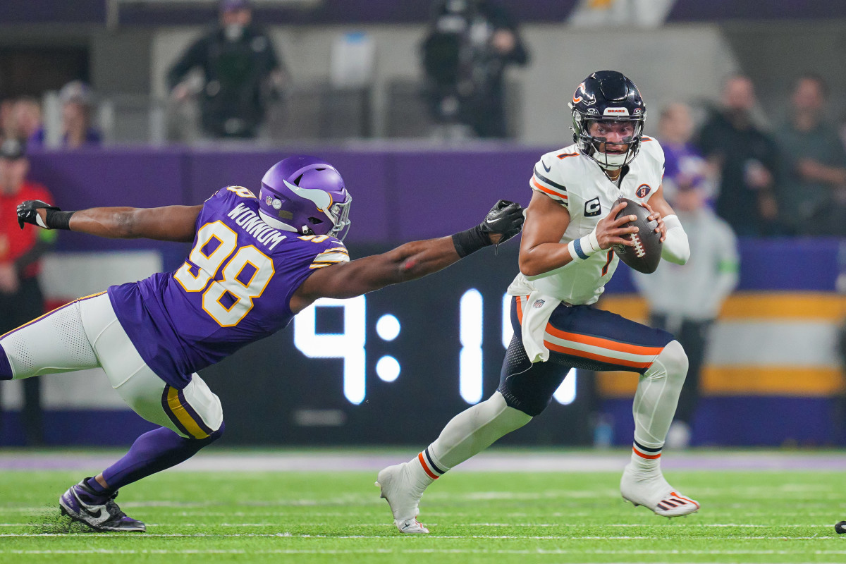 Chicago Bears quarterback Justin Fields scrambles away from Minnesota Vikings linebacker D.J. Wonnum in the first quarter at U.S. Bank Stadium.
