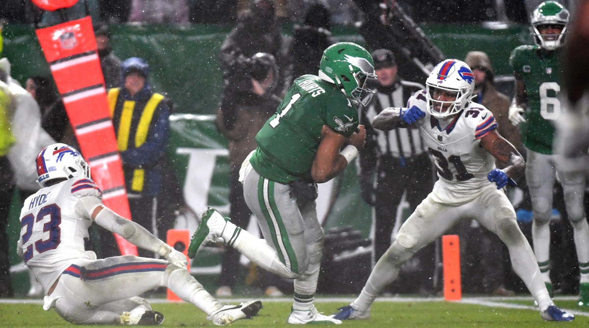 Jalen Hurts runs with the ball as Micah Hyde is on the ground behind him and Rasul Douglas stands by preparing to try to tackle