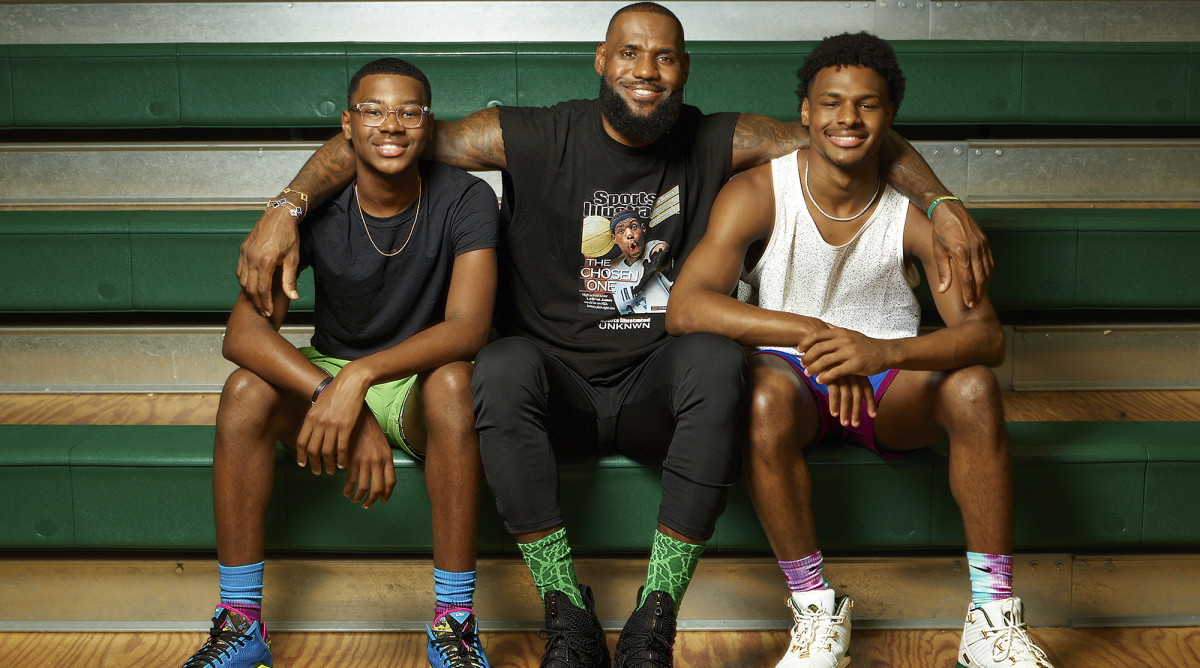 LeBron James, center, sits on bleachers with his arms around his kids: Bryce James, left, and Bronny James, right.