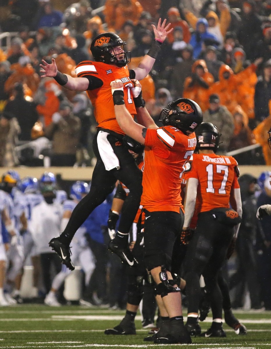 Nov 25, 2023; Stillwater, Oklahoma, USA; Oklahoma State's Alan Bowman (7) celebrates with Dalton Cooper (71) following a touchdown during second half against the Brigham Young Cougars at Boone Pickens Stadium. Mandatory Credit: Sarah Phipps-USA TODAY Sports