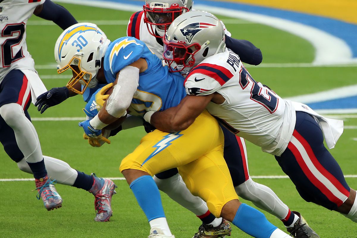 New England Patriots safety Adrian Phillips (21) tackles Los Angeles Chargers RB Austin Ekeler (30) at SoFi Stadium.