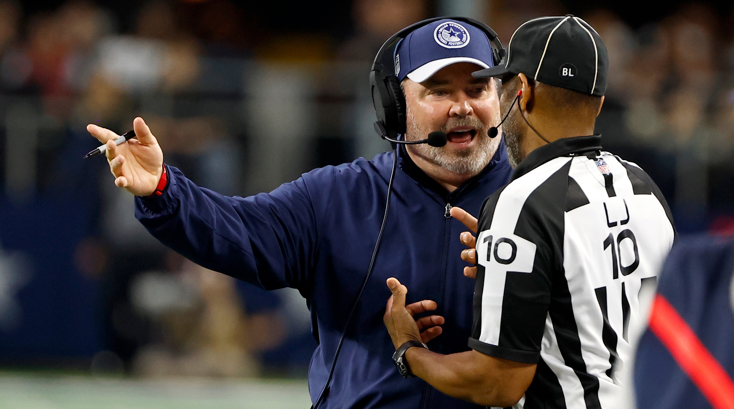 Cowboys coach Mike McCarthy, left, talks to line judge Julian Mapp (10) after a penalty was called against the Cowboys.