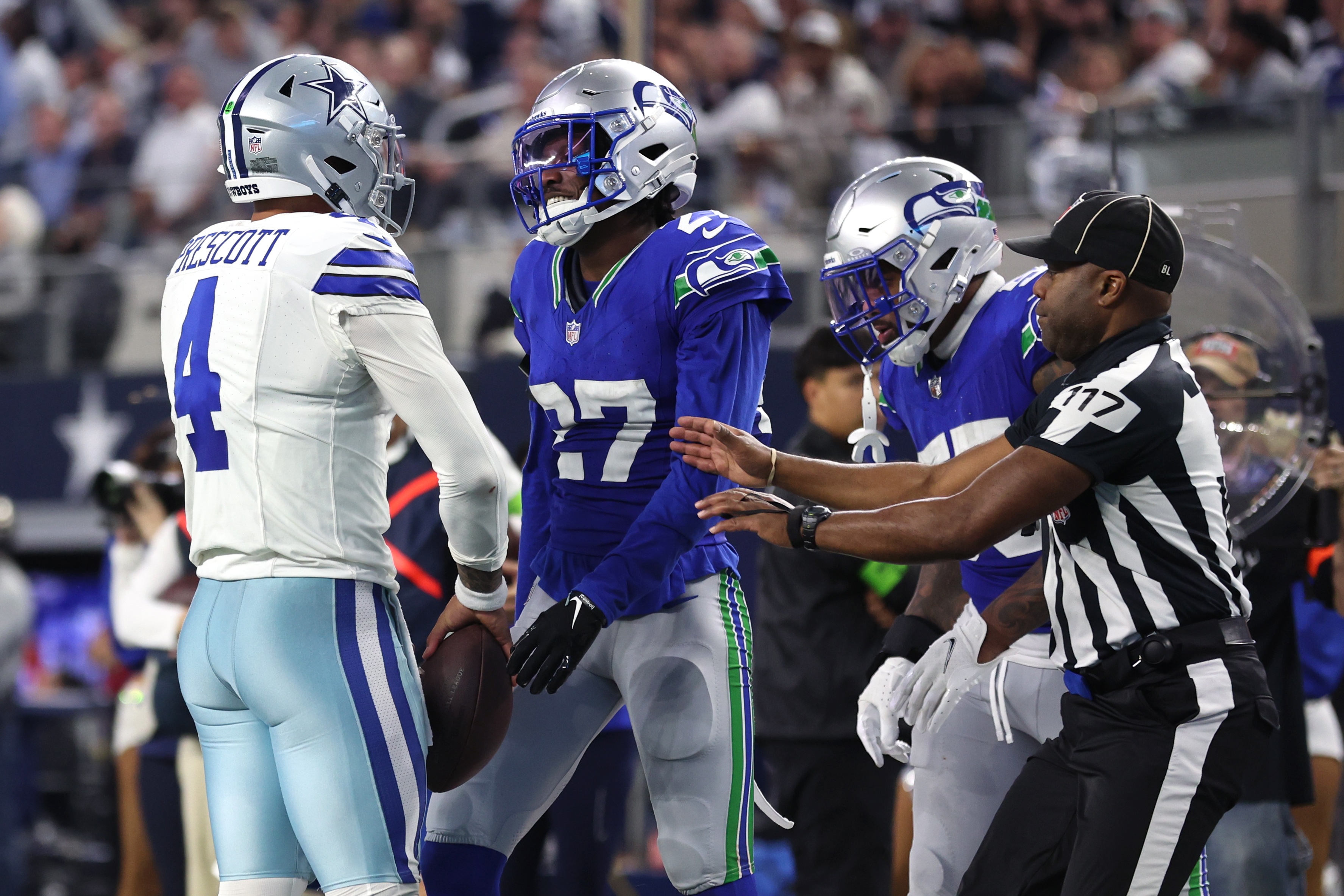 Dallas Cowboys quarterback Dak Prescott (4) and Seattle Seahawks cornerback Riq Woolen (27) talk after a play during the second half at AT&T Stadium.