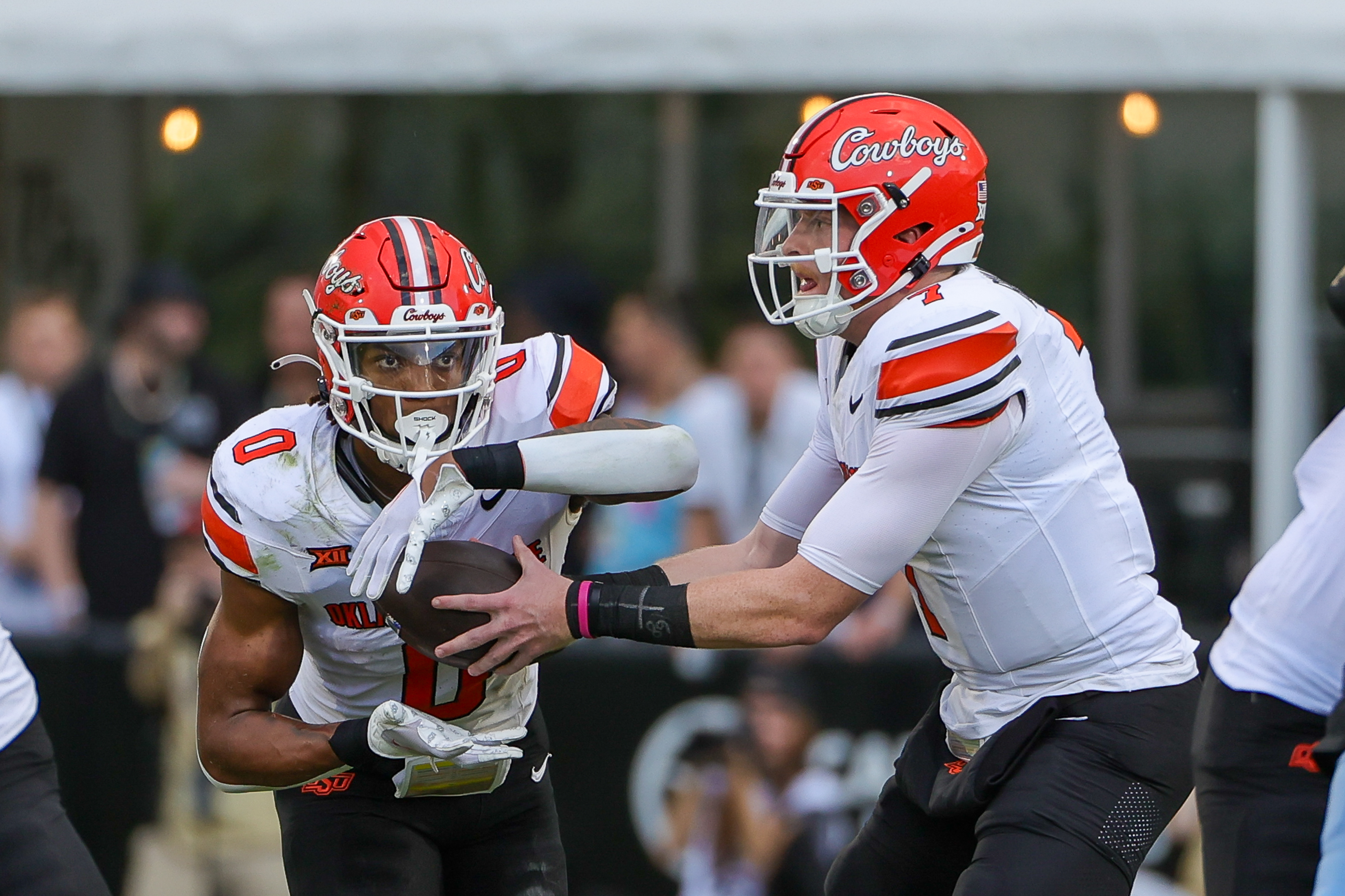 Nov 11, 2023; Orlando, Florida, USA; Oklahoma State Cowboys quarterback Alan Bowman (7) hands off to running back Ollie Gordon II (0) during the first quarter against the UCF Knights at FBC Mortgage Stadium. Mandatory Credit: Mike Watters-USA TODAY Sports