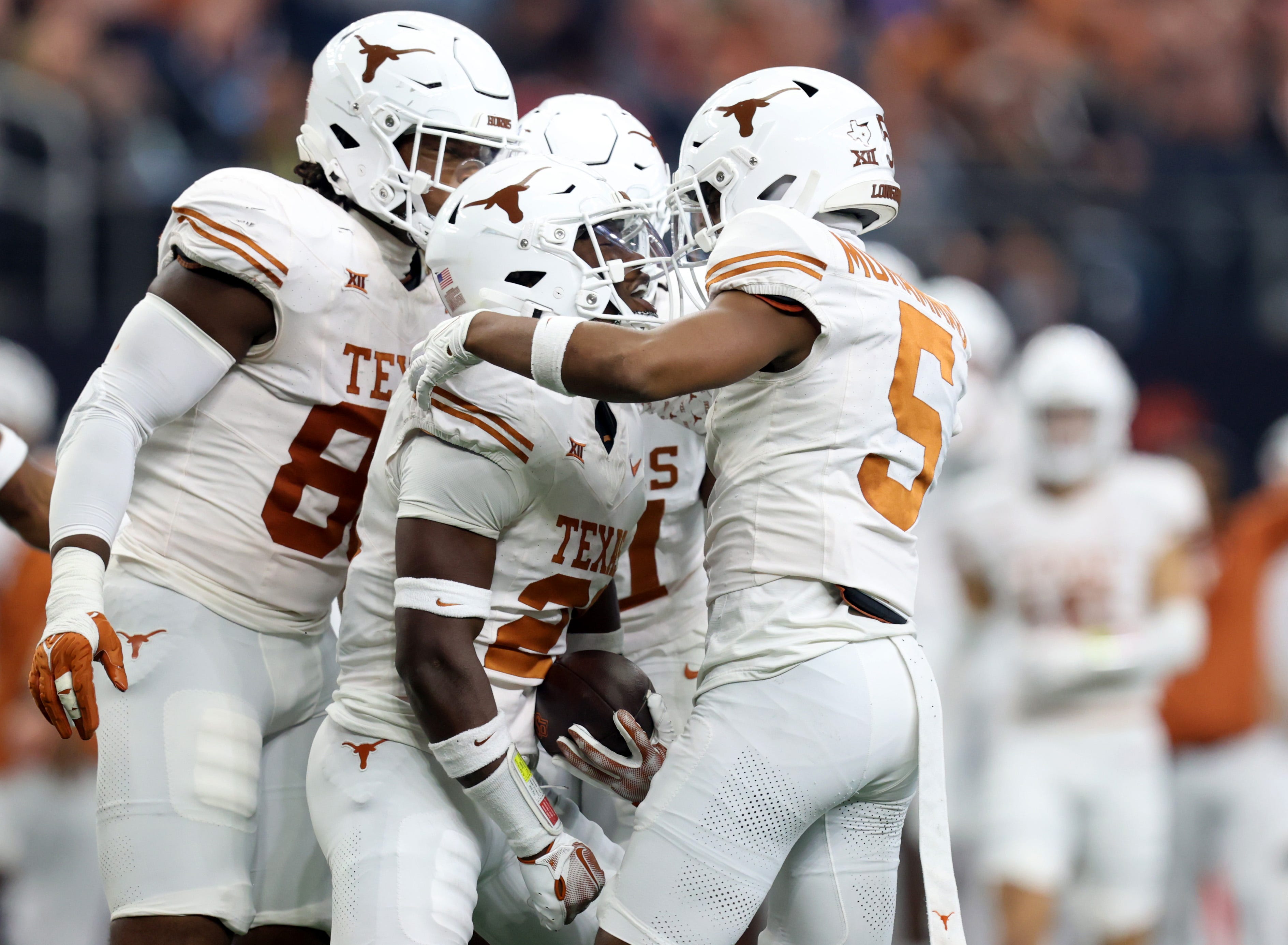 Texas's Kitan Crawford (21) celebrates an interception with Texas's Malik Muhammad (5) in the first half of the Big 12 Football Championship game between the Oklahoma State University Cowboys and the Texas Longhorns at the AT&T Stadium in Arlington, Texas, Saturday, Dec. 2, 2023.