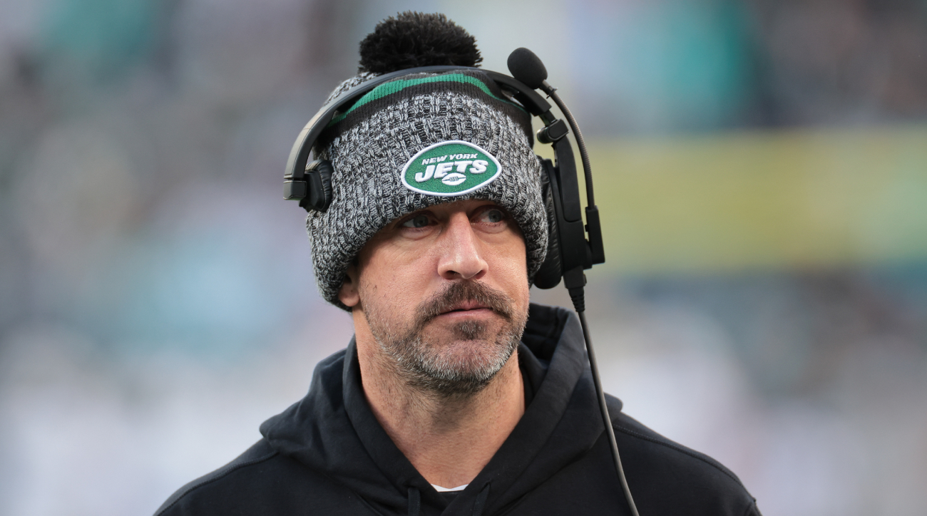 Jets quarterback Aaron Rodgers stands on the sidelines during a game.