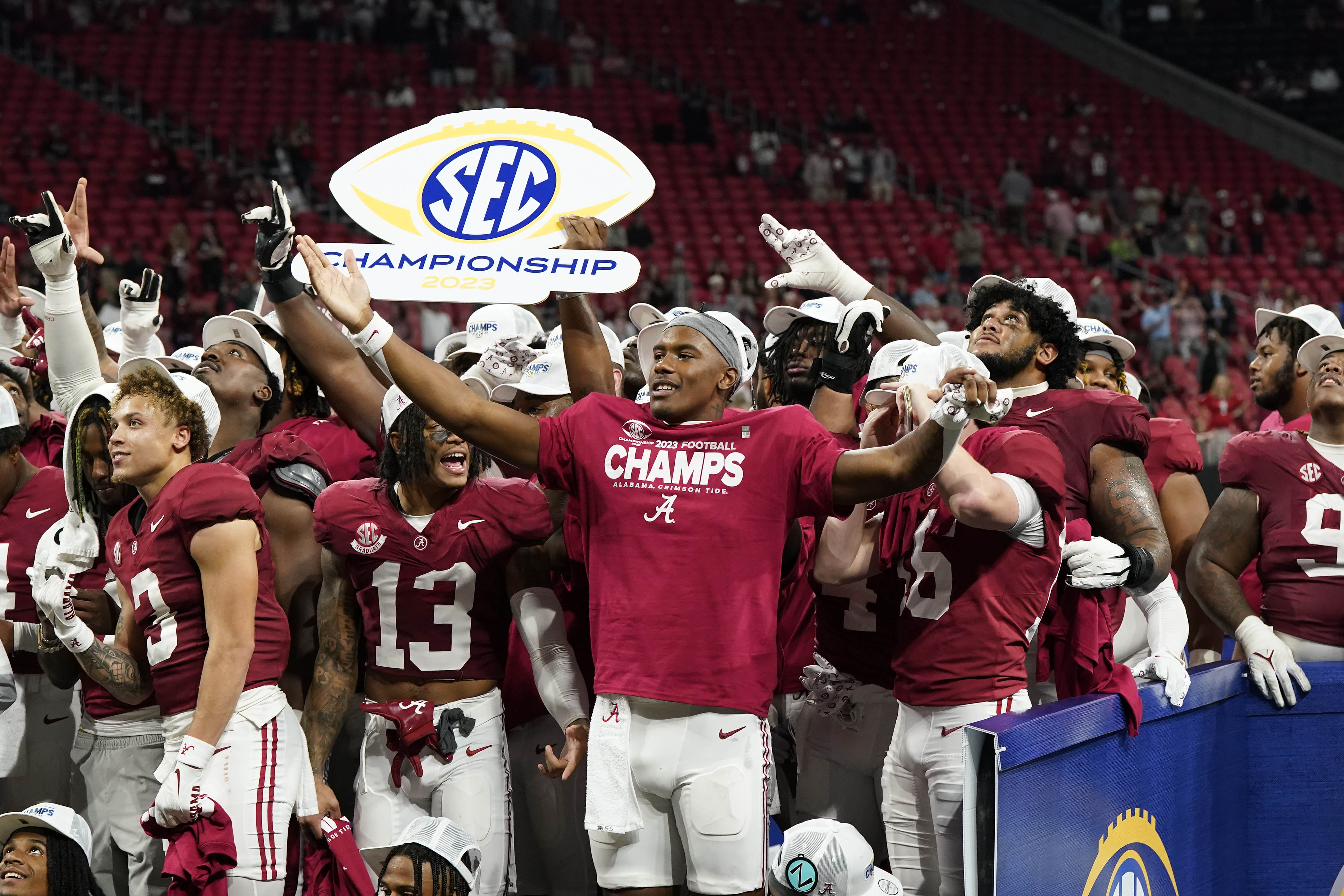 Alabama players stand and celebrate as they hold up an SEC CHampionship sign