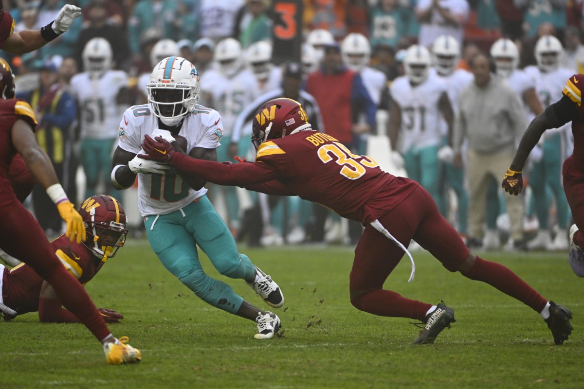 Miami Dolphins wide receiver Tyreek Hill (10) runs after a catch as Washington Commanders safety Percy Butler (35) defends during the first half at FedExField.