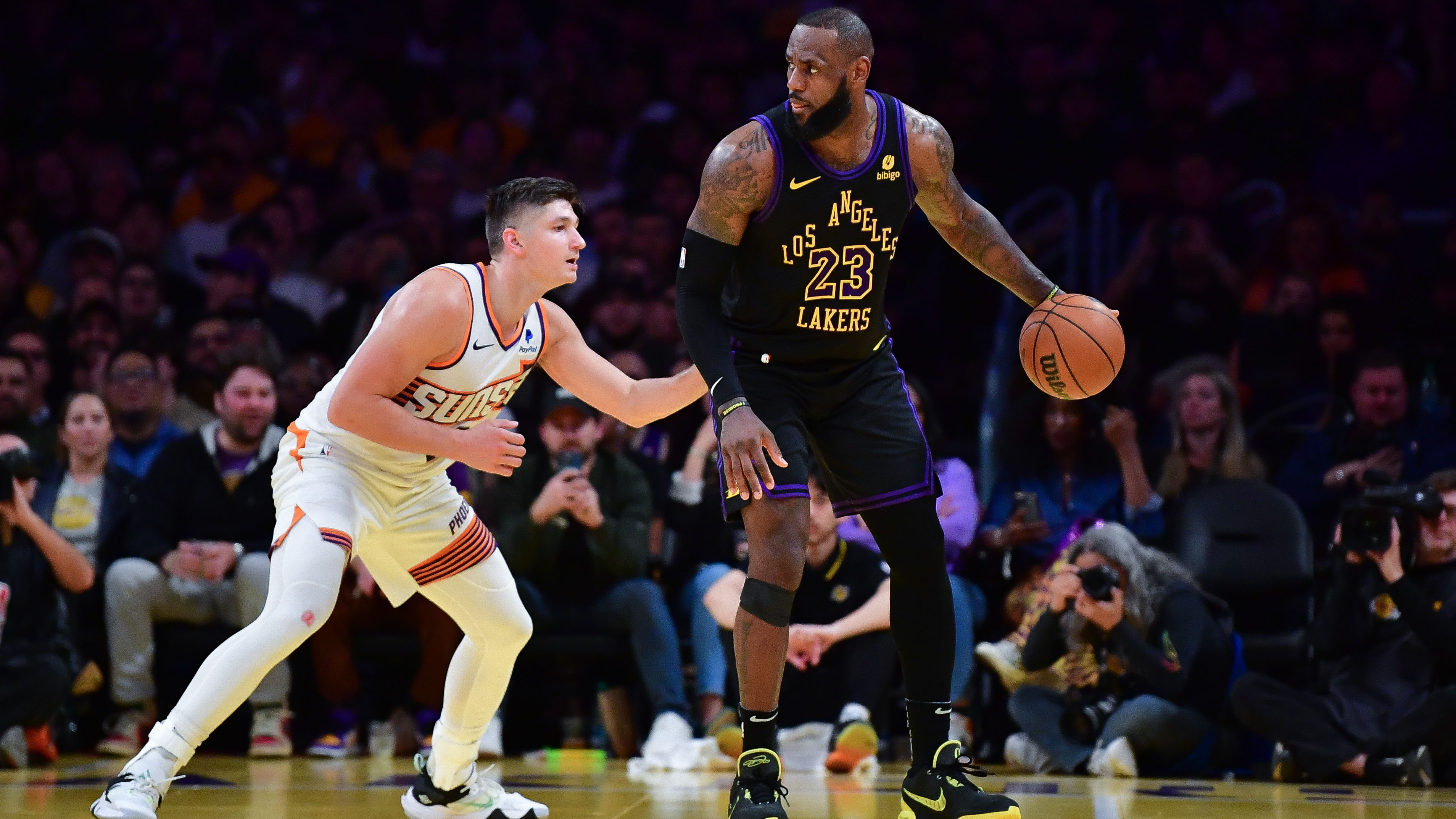 Los Angeles Lakers forward LeBron James moves the ball against Phoenix Suns guard Grayson Allen.