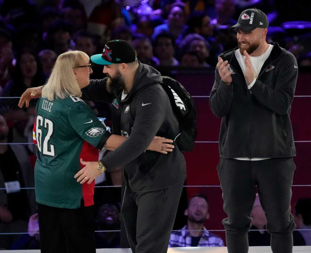 Donna Kelce hugs her son, Philadelphia Eagles center Jason Kelce, while her other son, Kansas City Chiefs tight end Travis Kelce, claps at the Footprint Center in downtown Phoenix during the NFL's Super Bowl Opening Night on Feb. 6, 2023.