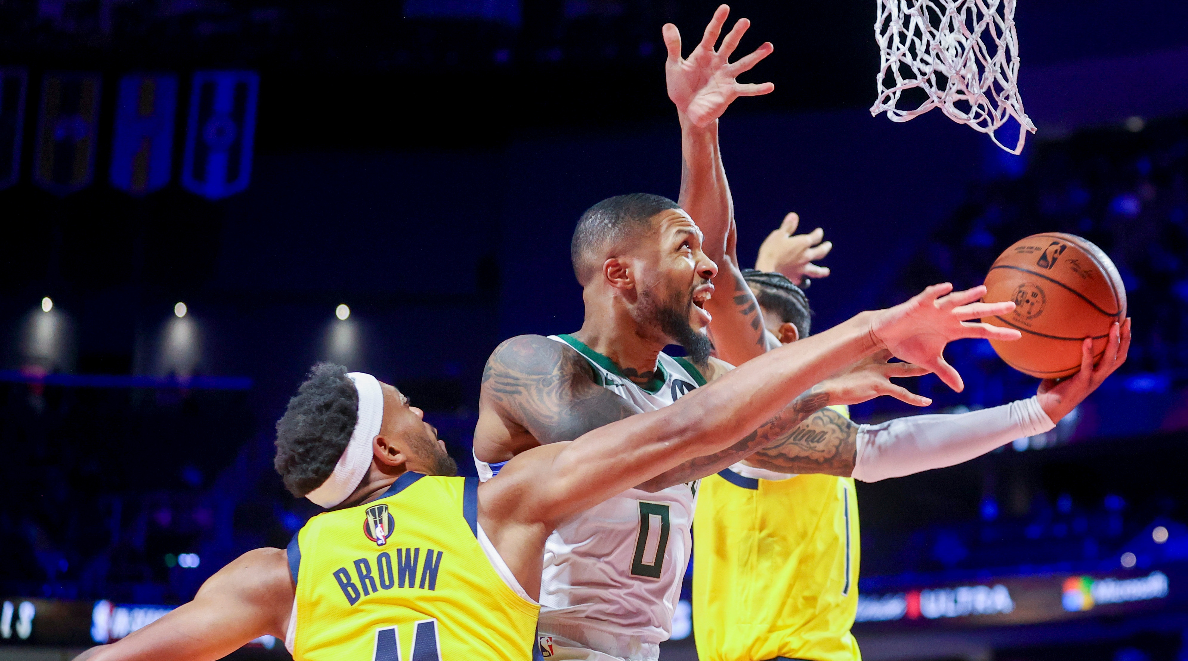 Bucks guard Damian Lillard goes up to shoot past Pacers forward Bruce Brown.