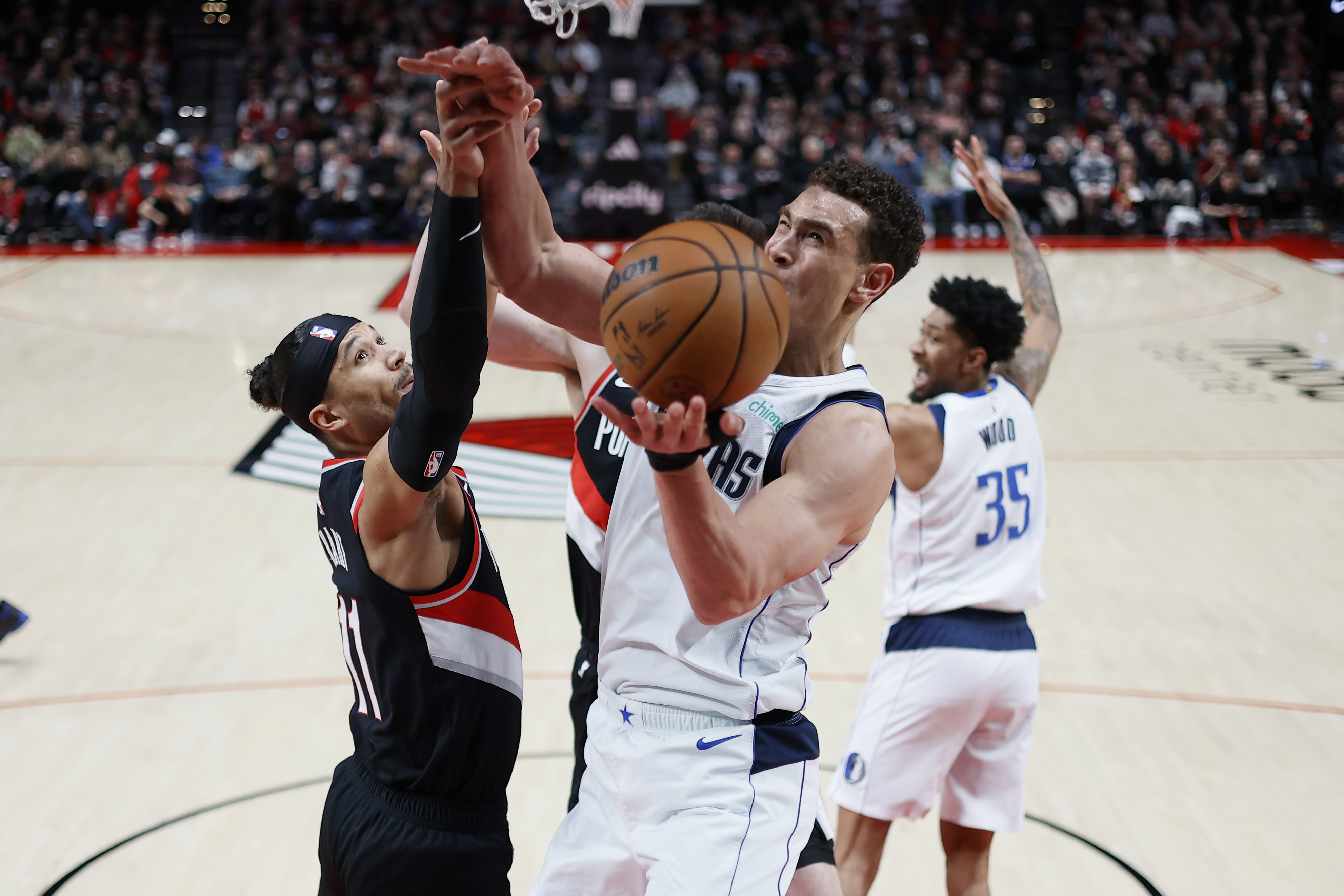 Mavs' Dwight Powell fights for a rebound with Trail Blazers' Josh Hart.