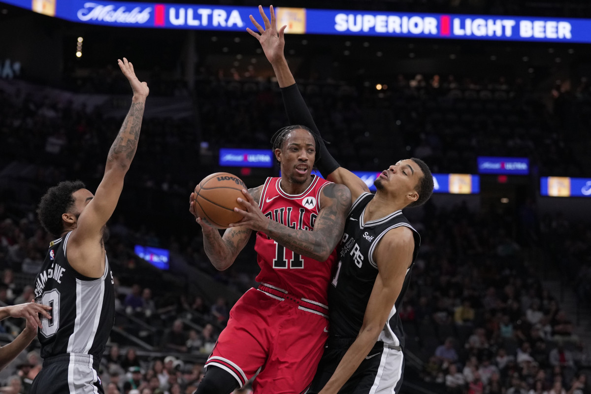 Chicago Bulls forward DeMar DeRozan (11) moves in against San Antonio Spurs forward Julian Champagnie (30) and center Victor Wembanyama (1) in the first half at the Frost Bank Center.