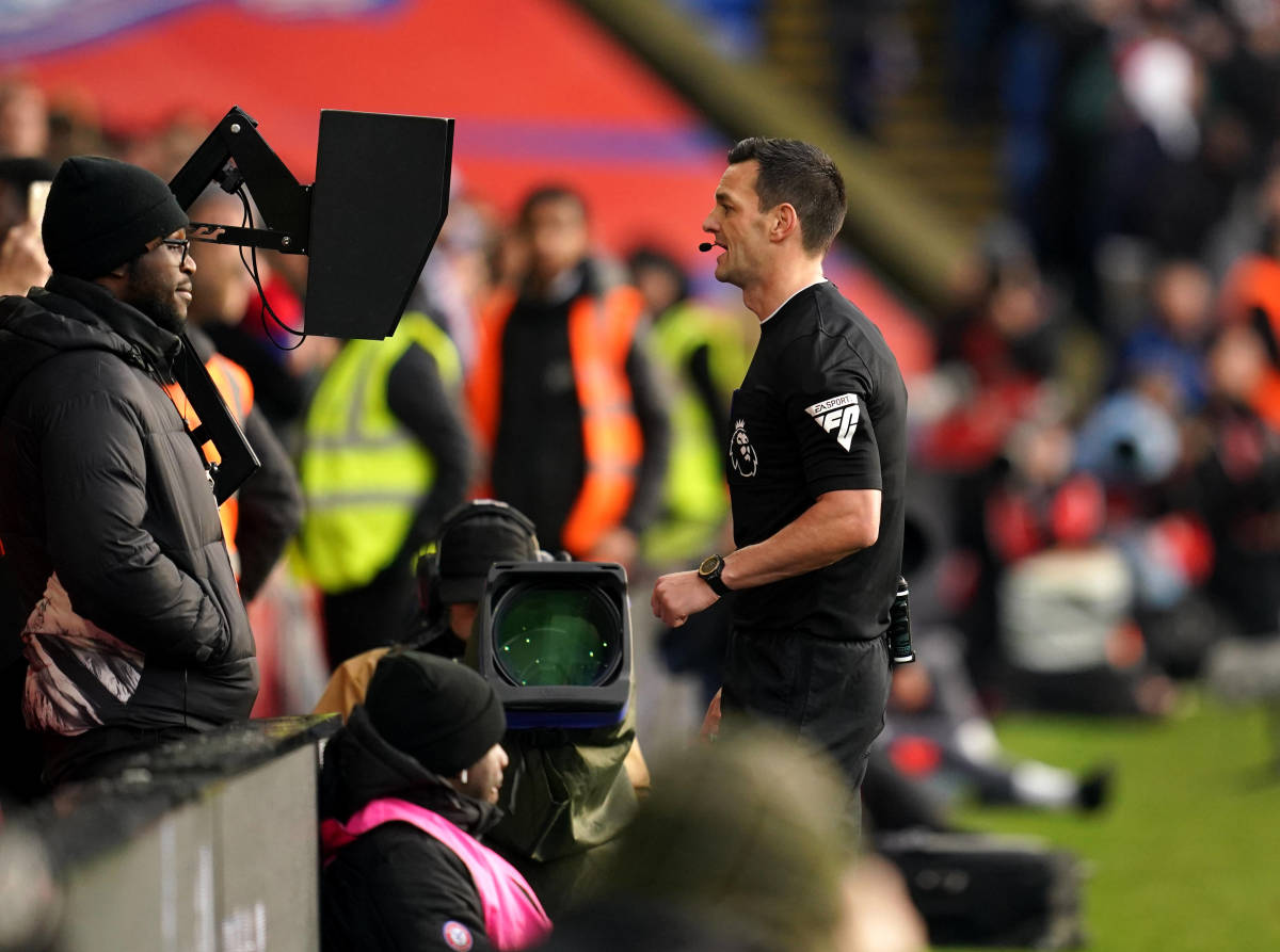 Referee Andrew Madley pictured looking at the VAR monitor during a Premier League game between Crystal Palace and Liverpool in December 2023