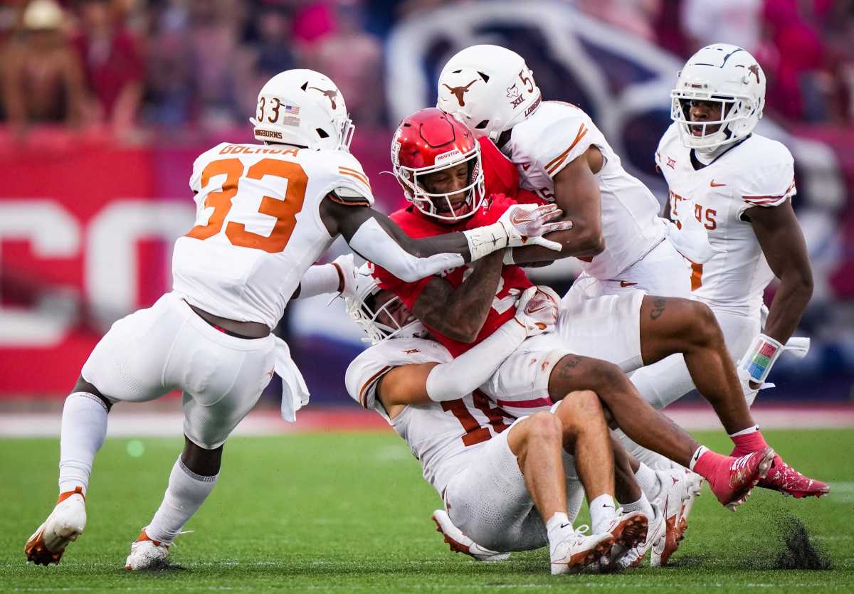 The Texas defense bring down Houston wide receiver Matthew Golden (2) in the fourth quarter of the Longhorn's game against the Houston Cougars at TDECU Stadium in Houston, Saturday, Oct. 21, 2023. Texas won the game 31-24. 