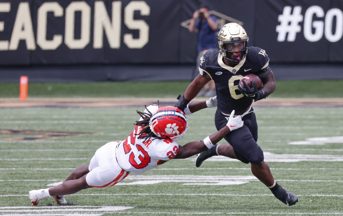 Wake Forest Demon Deacons running back Justice Ellison (6) runs past Clemson Tigers cornerback Toriano Pride (23) during the second half at Truist Field.