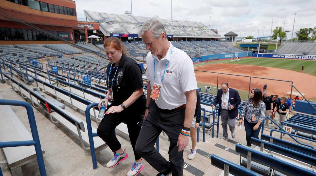 NCAA President Charlie Baker talks with Kelly Gatwood as Baker tours a stadium before a Women’s College World Series game