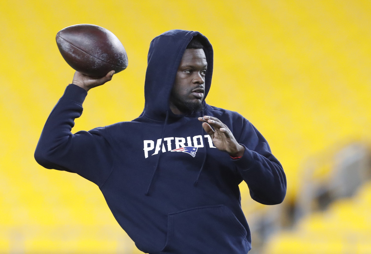 Malik Cunningham throws the ball with one hand wearing a Patriots’ hoodie