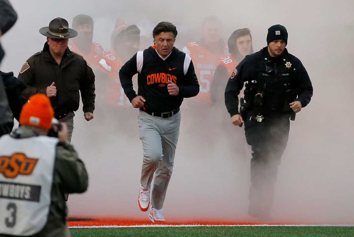 Oklahoma State head coach Mike Gundy runs on to the field before the college football game between the Oklahoma State University Cowboys and the Brigham Young Cougars at Boone Pickens Stadium in Stillwater, Okla., Saturday, Nov., 25, 2023.