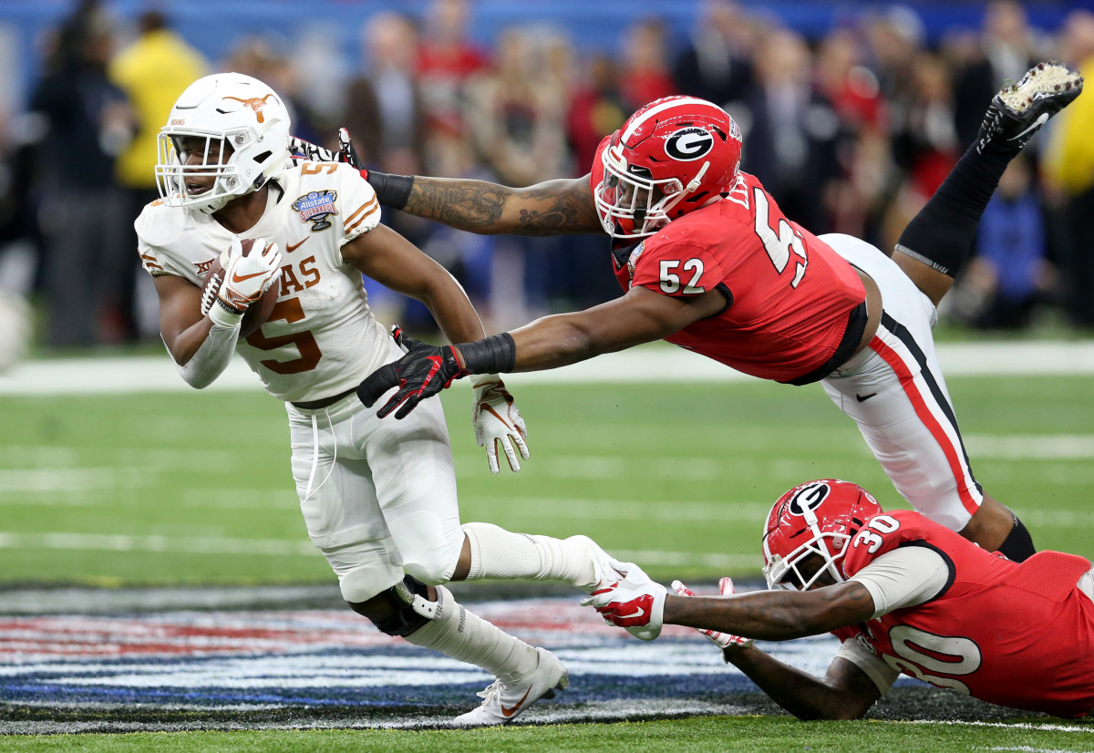 Texas Longhorns running back Tre Watson (5) is defended by Georgia Bulldogs defensive lineman Tyler Clark (52) and linebacker Tae Crowder (30) in the first quarter of the 2019 Sugar Bowl at the Merced...