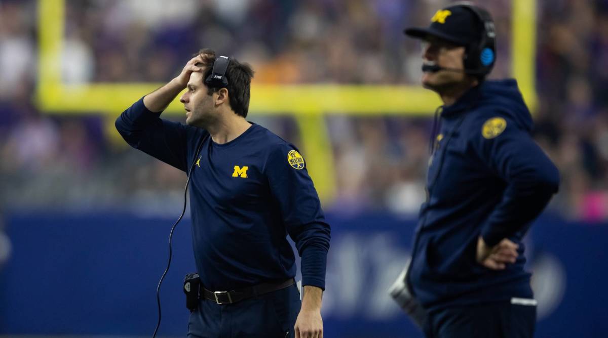 Michigan assistant coach George Helow and head coach Jim Harbaugh react to a play in the Fiesta Bowl.