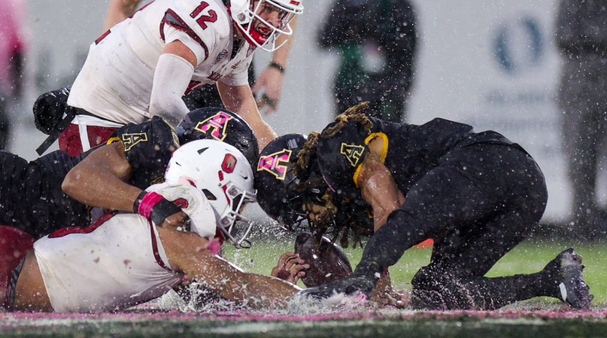 Miami (Ohio) and Appalachian State players jostle for one of the 2023 Cure Bowl’s 13 fumbles.