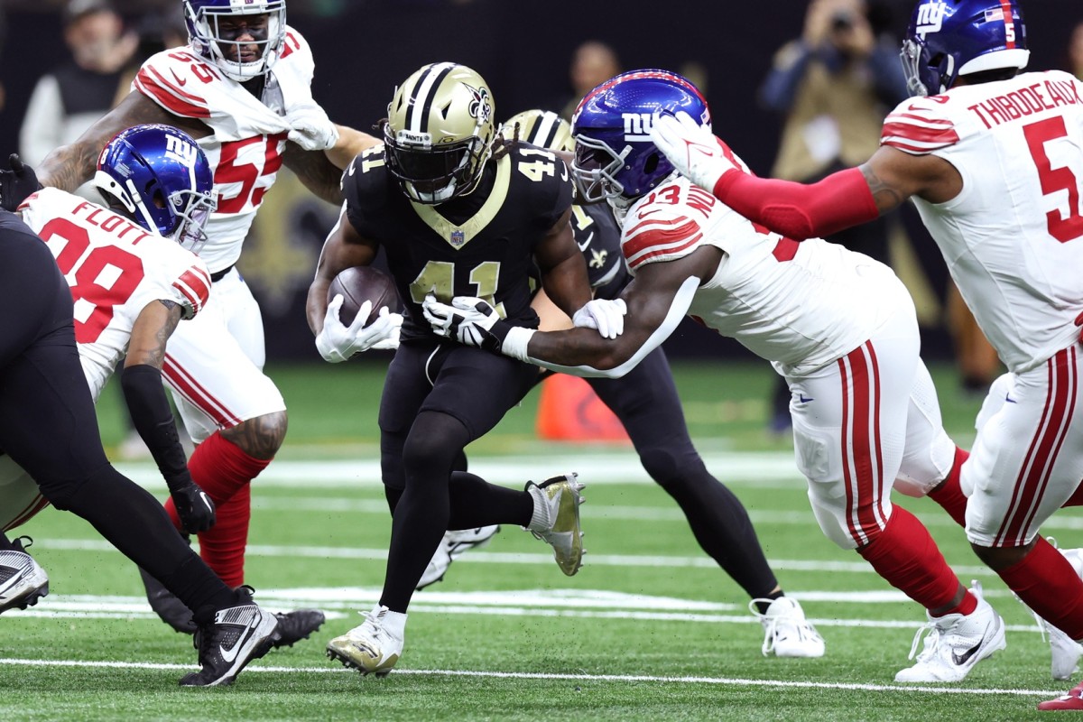 Dec 17, 2023; New Orleans, Louisiana, USA; New Orleans Saints running back Alvin Kamara (41) runs the ball while defended by New York Giants defensive tackle Rakeem Nunez-Roches (93) during the first half at Caesars Superdome.
