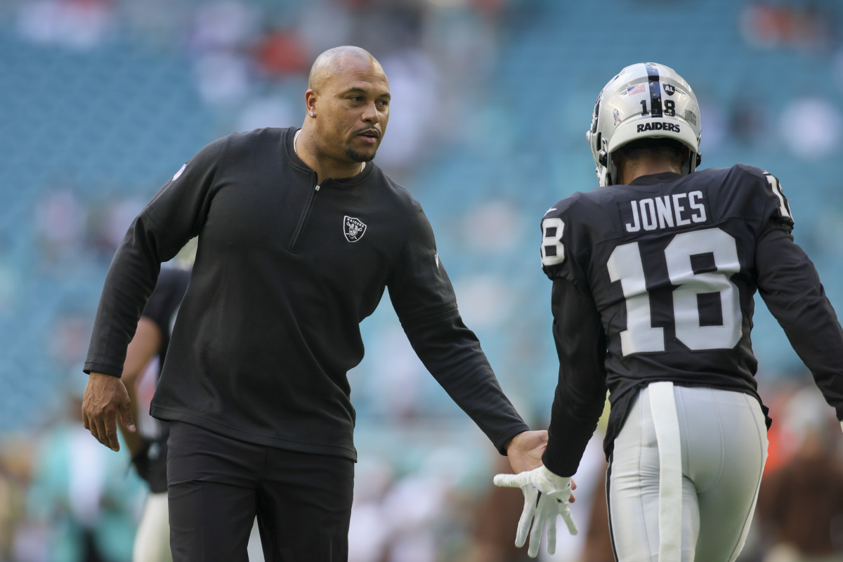 Antonio Pierce high fives Jack Jones as he runs off the field