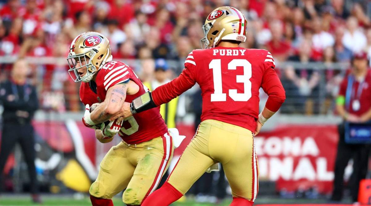 Brock Purdy hands the ball off to Christian McCaffrey against the Cardinals.