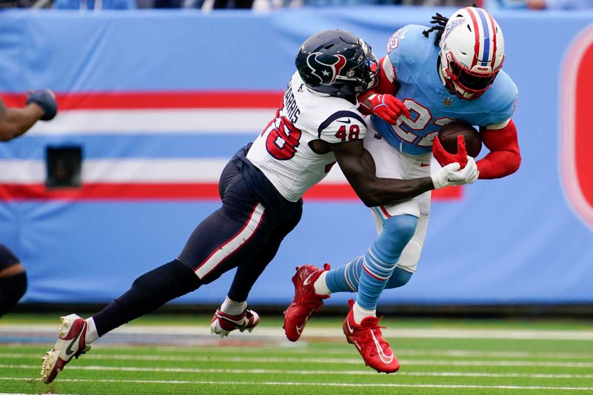 Tennessee Titans running back Derrick Henry (22) is tackled by Houston Texans linebacker Christian Harris (48) during the first quarter at Nissan Stadium in Nashville, Tenn., Sunday, Dec. 17, 2023