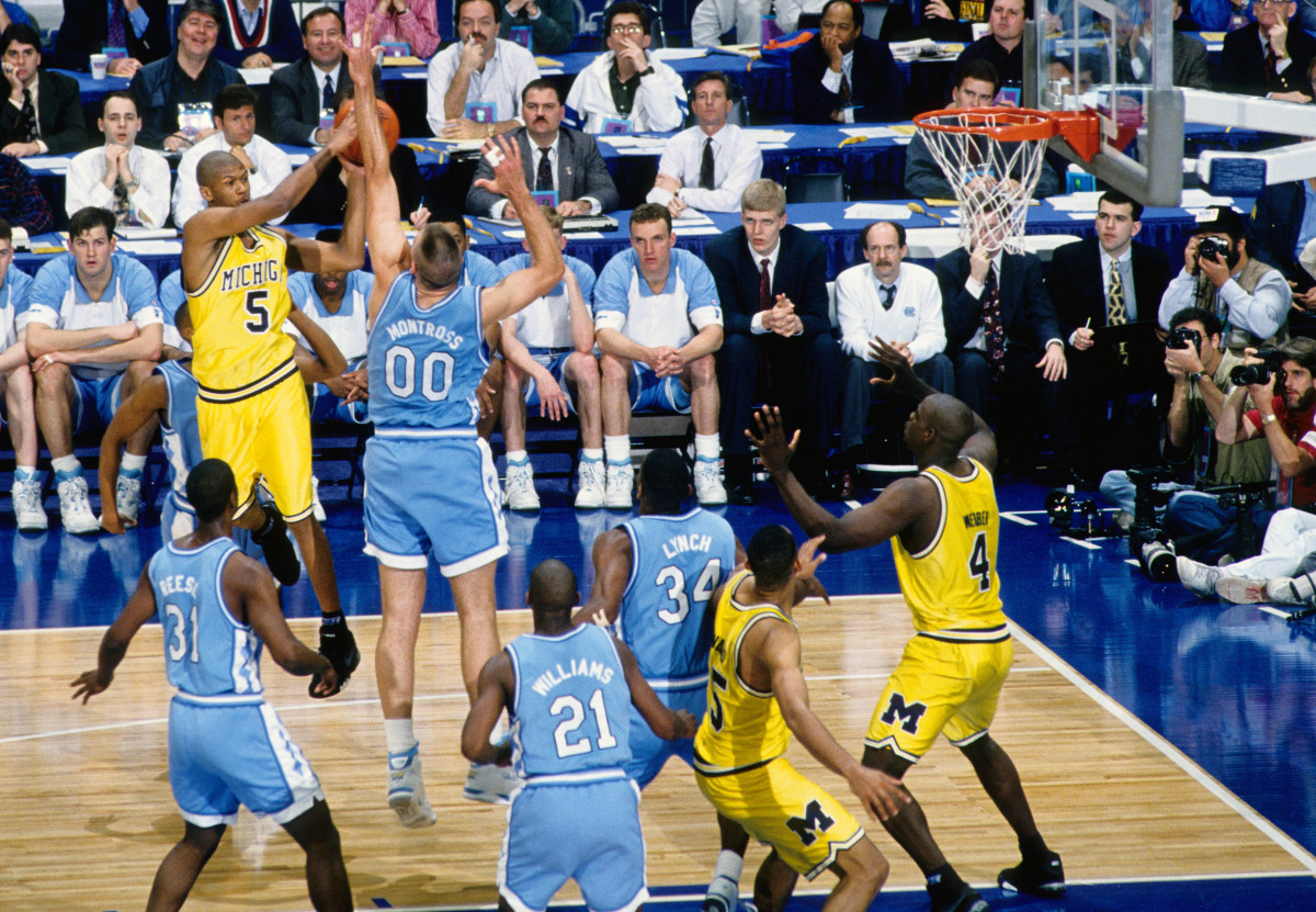 Michigan Wolverines guard Jalen rose passes the ball while being defended by North Carolina Tar Heels center Eric Montross during the 1993 NCAA Men's Final Four championship game at the Superdome. North Carolina defeated Michigan 77-71.