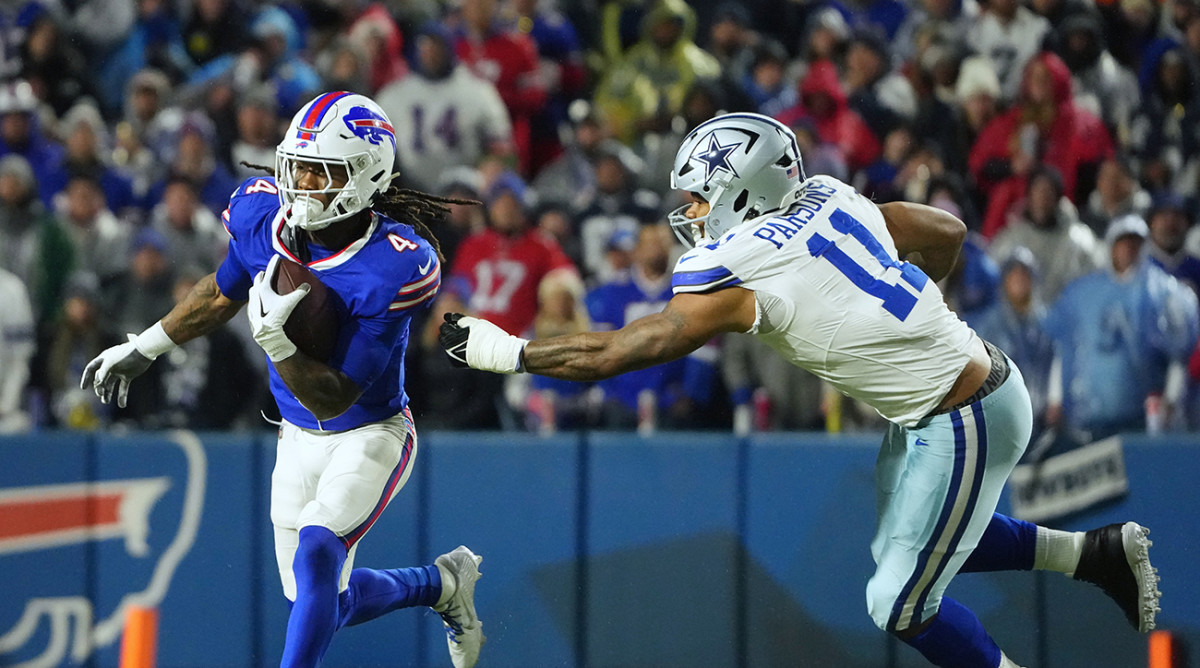 Bills running back James Cook (4) runs the ball pressured by Cowboys linebacker Micah Parsons (11) in the second half at Highmark Stadium.