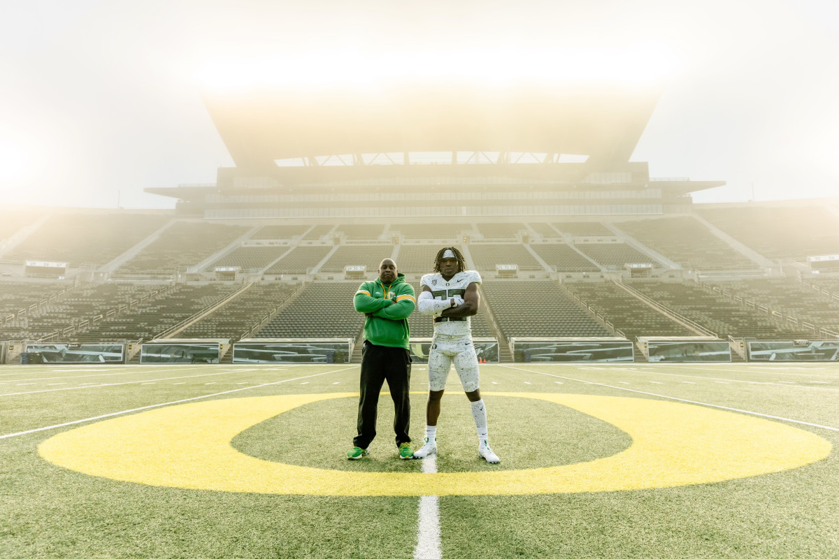 Running back Jay Harris poses with Oregon coach Carlos Locklyn inside Autzen Stadium.