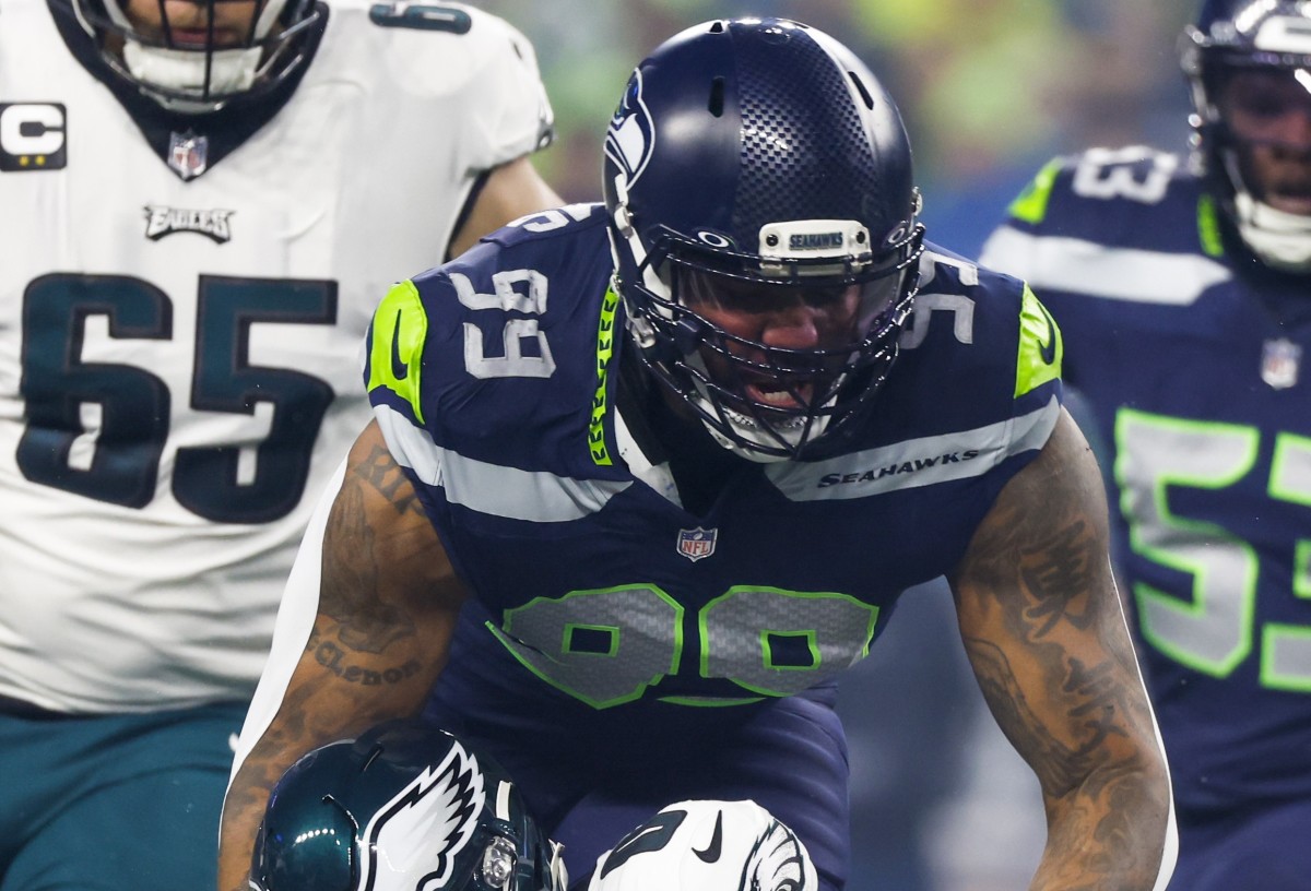 Seattle Seahawks defensive end Leonard Williams (99) tackles Philadelphia Eagles running back D'Andre Swift (0) for a loss during the first quarter at Lumen Field.