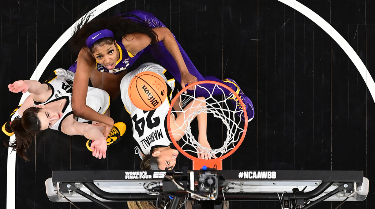 Iowa’s Caitlin Clark and LSU’s Angel Reese fight for a rebound.