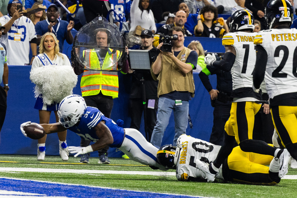 Dec 16, 2023; Indianapolis, Indiana, USA; Indianapolis Colts running back Tyler Goodson (31) dives for the end zone while Pittsburgh Steelers linebacker Elandon Roberts (50) defends in the first half at Lucas Oil Stadium.