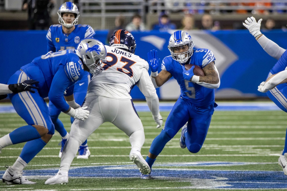 Detroit Lions running back David Montgomery (5) runs with the ball past Denver Broncos defensive tackle D.J. Jones (93) in the second half at Ford Field.