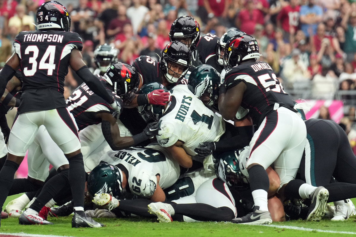 Jalen Hurts pushes through on top of Jason Kelce while Cardinals players try to stop him