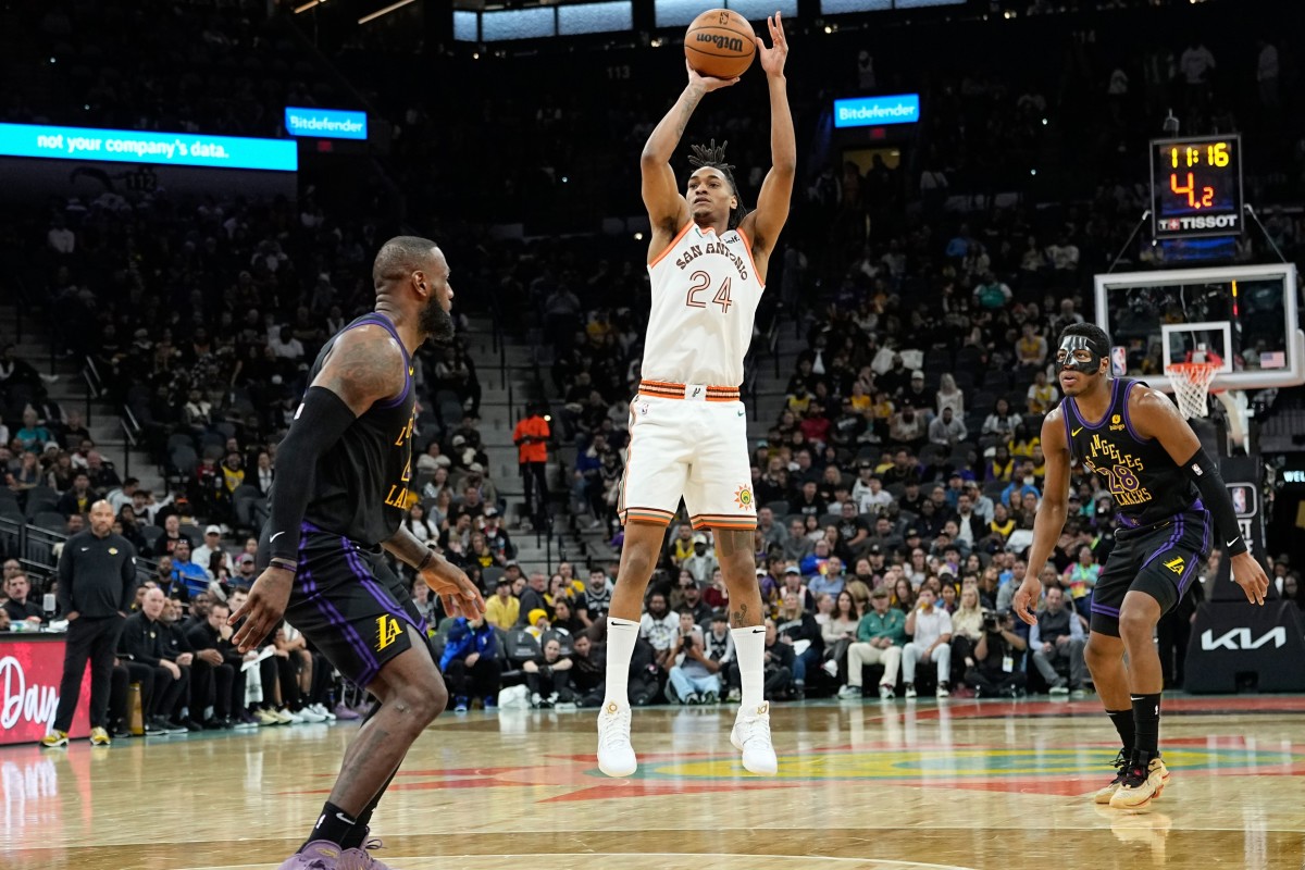 San Antonio Spurs guard Devin Vassell shoots while defended by Los Angeles Lakers forwards LeBron James and Rui Hachimura