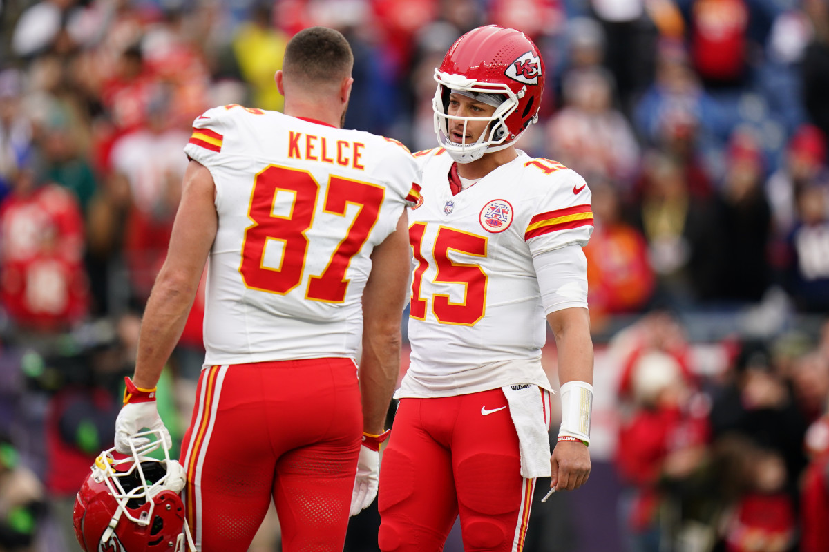Travis Kelce stands talking to Patrick Mahomes