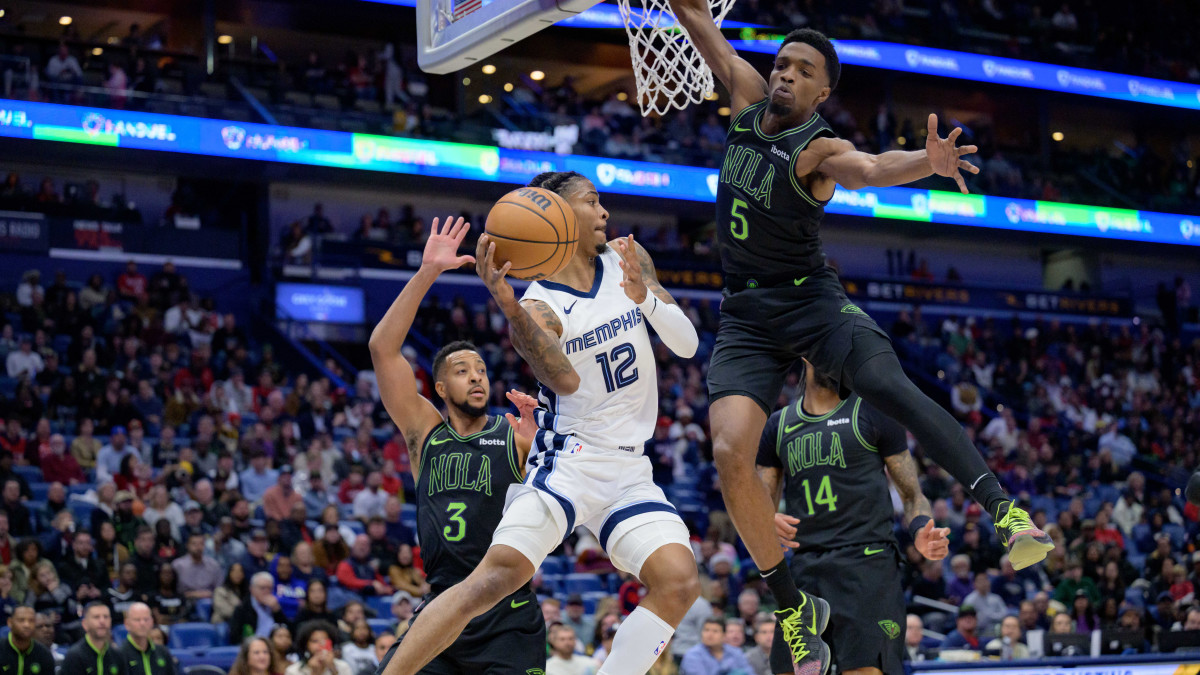 Memphis Grizzlies guard Ja Morant goes up against New Orleans Pelicans guard CJ McCollum.