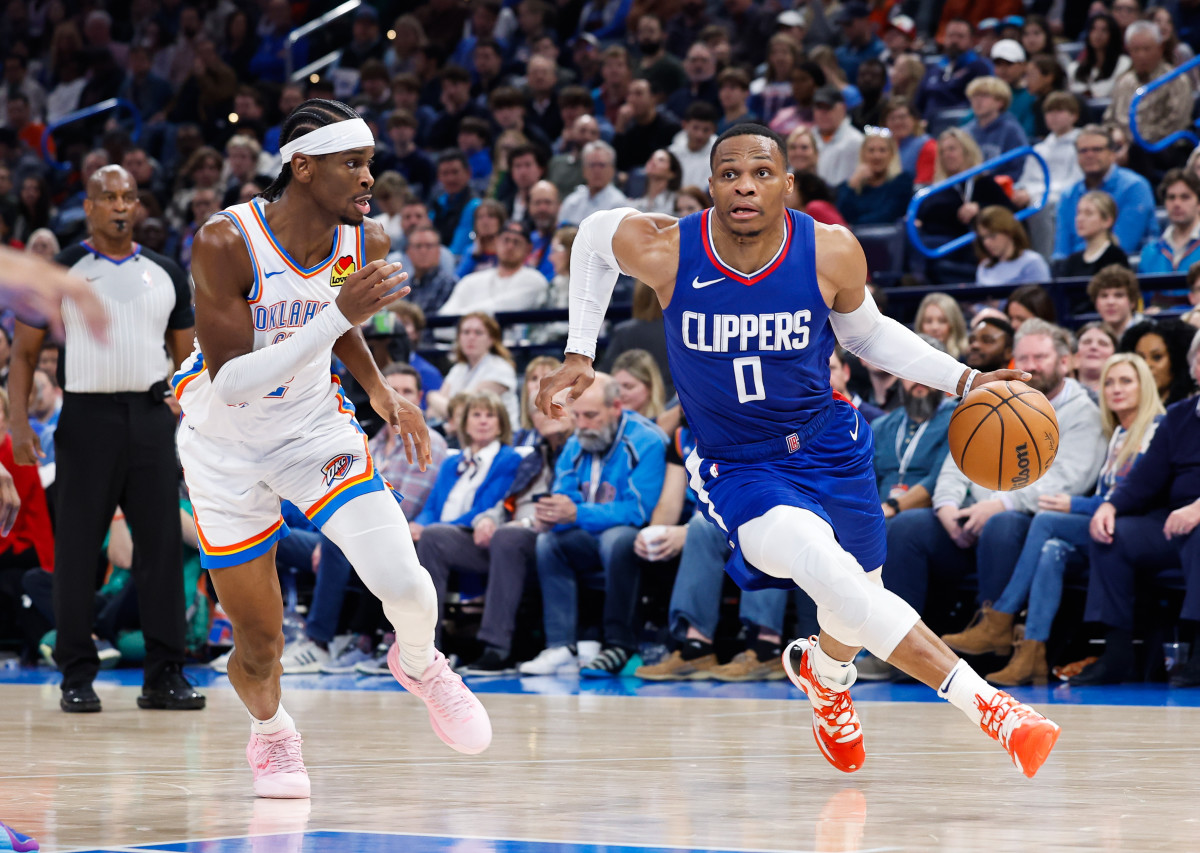 Dec 21, 2023; Oklahoma City, Oklahoma, USA; LA Clippers guard Russell Westbrook (0) drives around Oklahoma City Thunder guard Shai Gilgeous-Alexander (2) during the second half at Paycom Center. 