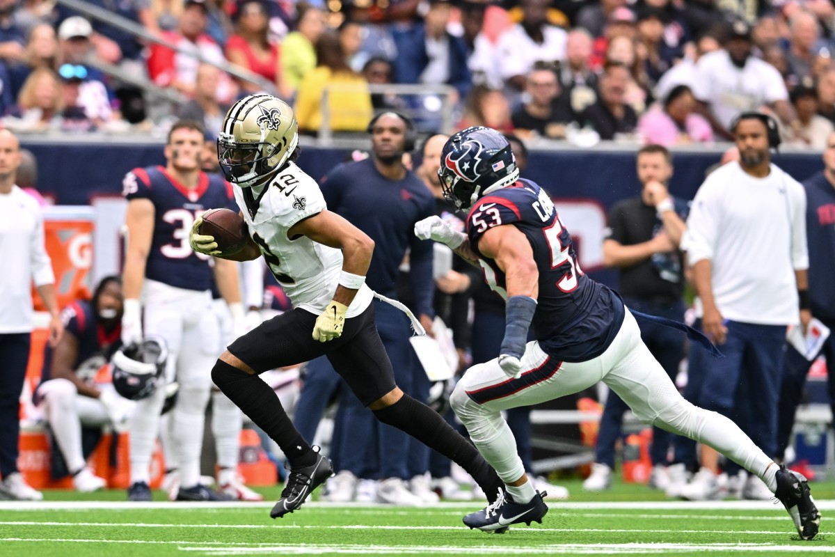 New Orleans Saints receiver Chris Olave (12) runs after a reception past Houston Texans linebacker Blake Cashman (53). Mandatory Credit: Maria Lysaker-USA TODAY Sports