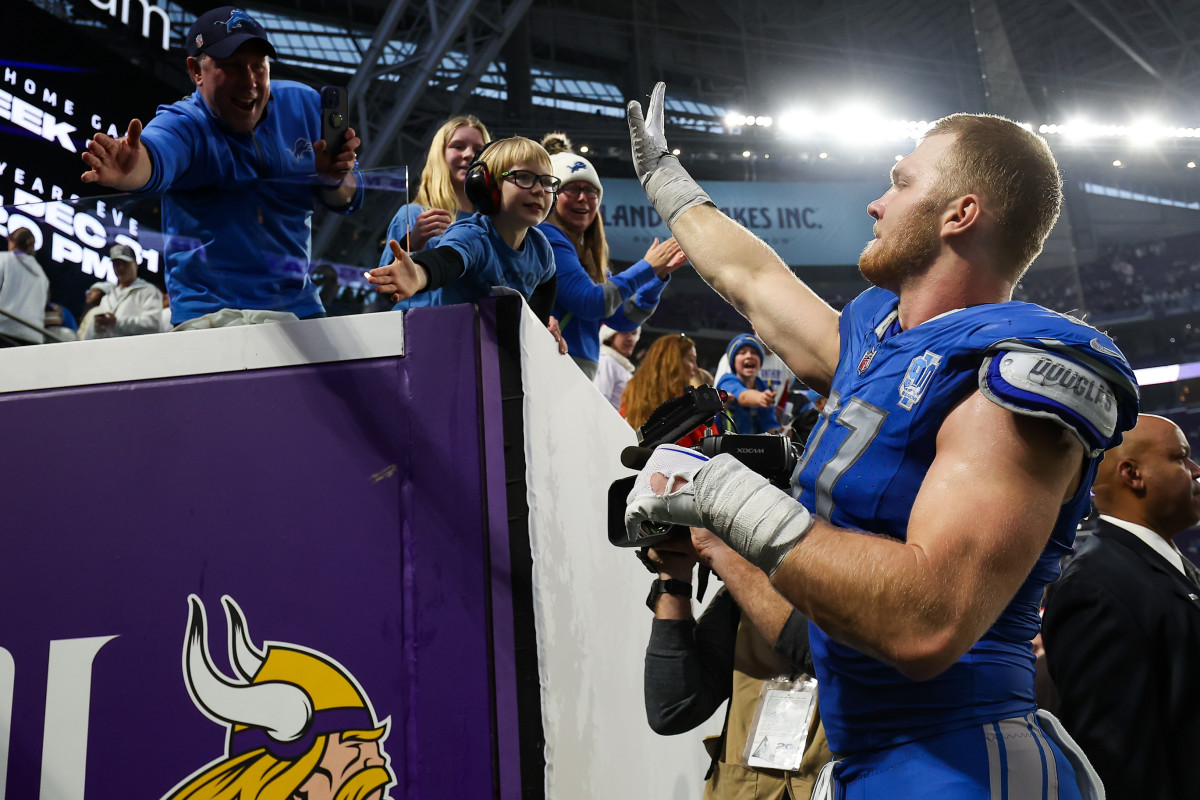 Detroit Lions defensive end Aidan Hutchinson celebrates with fans after the the team’s NFC North-clinching win over the Minnesota Vikings.