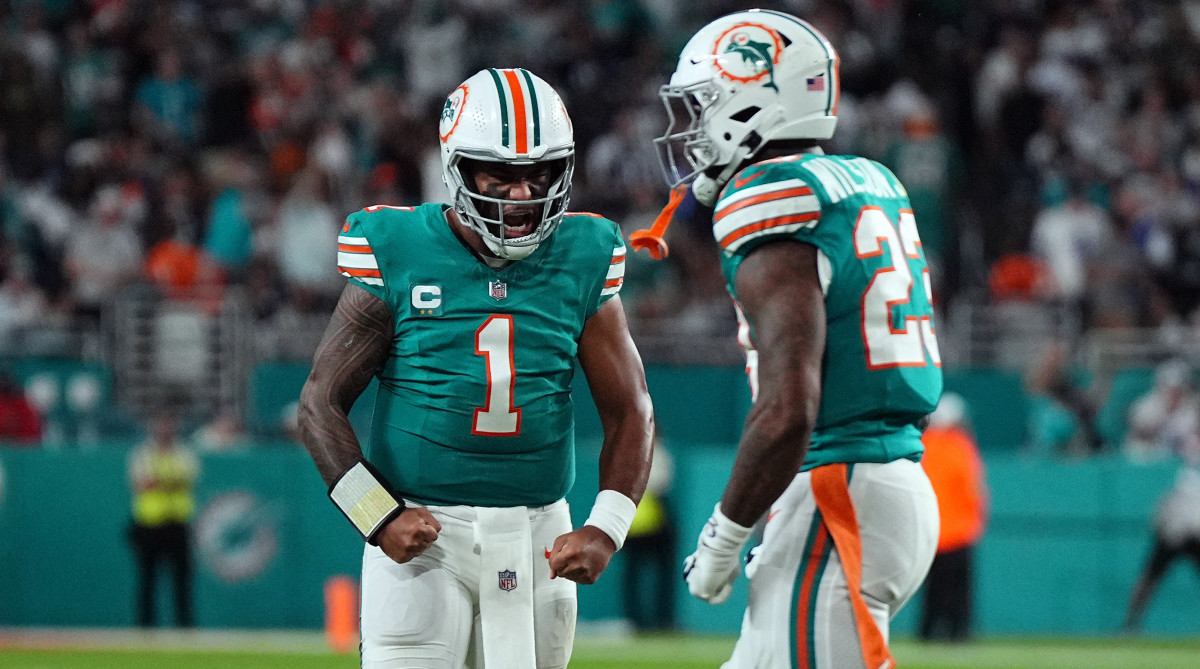 Dolphins quarterback Tua Tagovailoa, left, and running back Jeff Wilson Jr. celebrate after Wilson rushed for a first down against the Dallas Cowboys