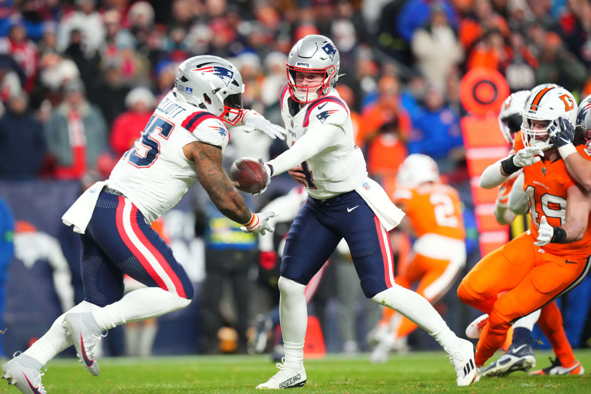 New England Patriots quarterback Bailey Zappe (4) hands off to running back Ezekiel Elliott (15) in the first quarter against the Denver Broncos at Empower Field at Mile High.